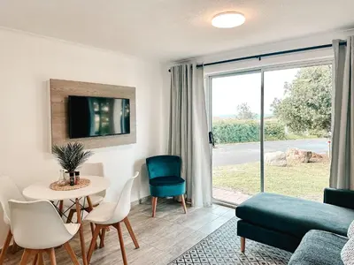 a living room with a couch and a table and chairs at Ebb & Flow in Hermanus