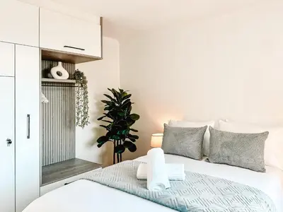 a bedroom with a white bed with gray pillows at Ebb & Flow in Hermanus