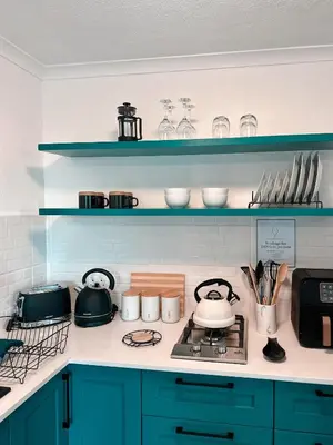 a kitchen with blue cabinets and a stove with pots and pans at Ebb & Flow in Hermanus
