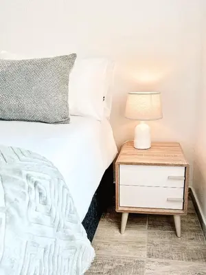 a bedroom with a bed and a nightstand with a lamp at Ebb & Flow in Hermanus