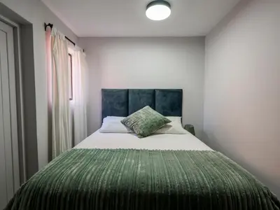a bedroom with a large bed with a green blanket at Imoyo Ocean Retreat in Hermanus