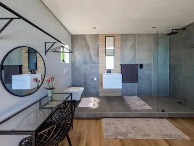 a bathroom with a shower and a sink and a mirror at Imoyo Ocean Retreat in Hermanus