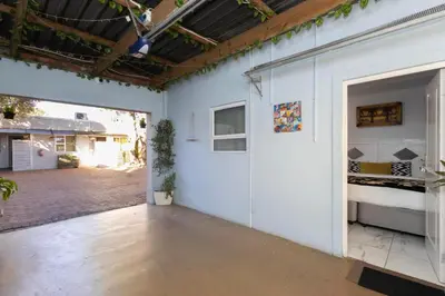 a room with a white wall and a bedroom at Serena Inn Room 8 in Cape Town