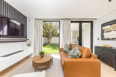 a living room with a couch and a tv at Aan de Meul Luxury Apartments in Stellenbosch