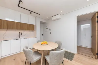 a kitchen and dining room with a wooden table and chairs at Aan de Meul Luxury Apartments in Stellenbosch