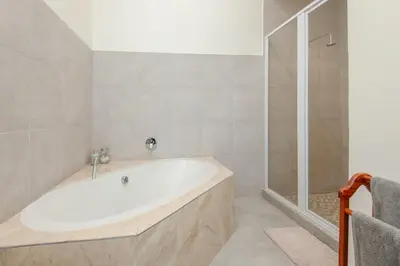 a bathroom with a tub and a shower at Iets Nuuts in Hermanus