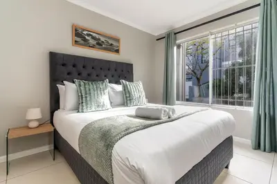 a bedroom with a large bed with a window at South Views 14 in Cape Town