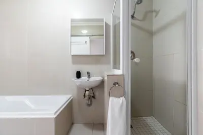 a white bathroom with a sink and a shower at South Views 14 in Cape Town