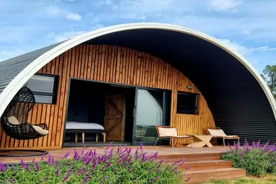 a house with an arched roof with a patio at La Vita Romantic Getaway Cabin in Wellington