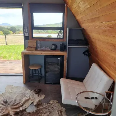 a room with a desk and a chair in a tiny house at La Vita Romantic Getaway Cabin in Wellington