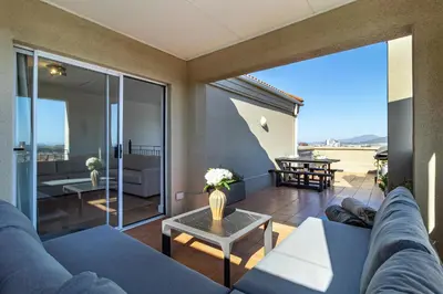 a living room with a couch and a table at 2 Bedroom, Mountain View Penthouse, Century City in Cape Town