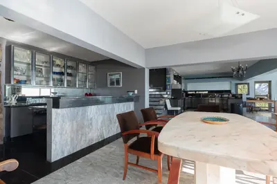 a kitchen and dining room with a table and chairs at Gordons Bay Villa with Pool in Gordonʼs Bay