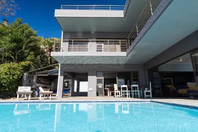 a house with a swimming pool in front of a house at Gordons Bay Villa with Pool in Gordonʼs Bay