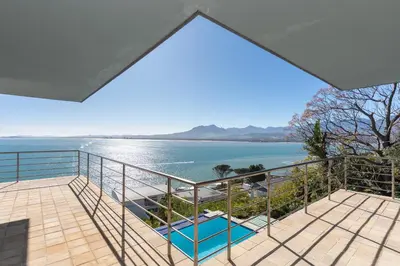 a balcony with a view of the water at Gordons Bay Villa with Pool in Gordonʼs Bay