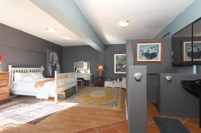 a bedroom with a bed and a desk in it at Gordons Bay Villa with Pool in Gordonʼs Bay