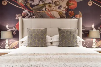 a bedroom with a white bed with two lamps at 107 Dorpstraat Boutique Hotel in Stellenbosch