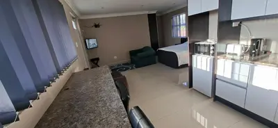 a hotel room with a bed and a kitchen and a room at Murray Guest Suite in Goodwood