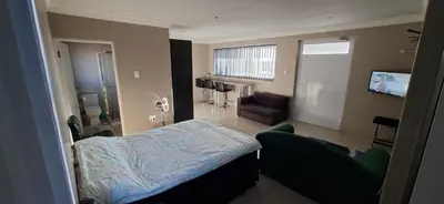 a small room with a bed and a chair at Murray Guest Suite in Goodwood