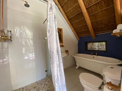 a bathroom with a tub and a toilet and a sink at The Welgemoed Guest House in Bellville