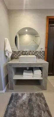 a bathroom with a sink and a large mirror at Kiewiets Nest in Victory Hill