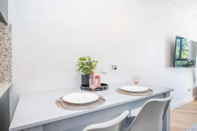 a dining room table with two white plates on it at 136 Paarl Studio With Onsite Parking Comforts in Paarl
