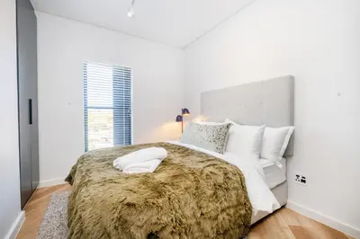 a white bedroom with a large bed with white pillows at Paarl 225 - Lux Modern 2 Bedroom Apartment with Parking in Paarl