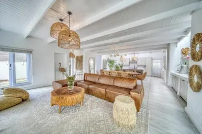 a living room with a couch and a table at Luxury Flamingo Villa at beach with Pool and Solar Back Up in Cape Town