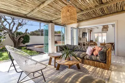 a living room with a couch and chairs at Luxury Flamingo Villa at beach with Pool and Solar Back Up in Cape Town