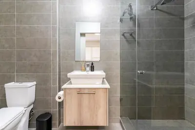 a bathroom with a toilet and a sink and a shower at Waters Edge Apartments by Propr in Cape Town