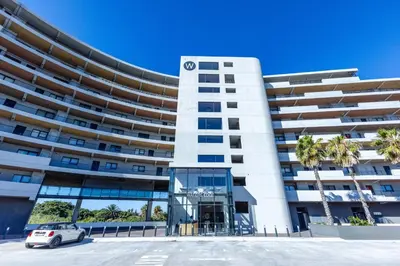a white car parked in front of a building at Waters Edge Apartments by Propr in Cape Town