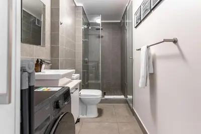 a bathroom with a toilet and a sink and a shower at Waters Edge Apartments by Propr in Cape Town