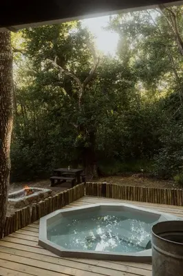 a hot tub sitting on a wooden deck at Glen Oakes Farm Stay in Hartebeest Rivier
