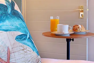 a table with a cup of coffee and a plate of food at Beach House, Pool, Braai, Patio, Water Sports in Hermanus