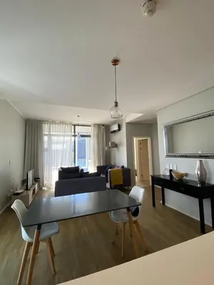 a living room with a couch and a table at Serene Global Capetown Axis in Cape Town