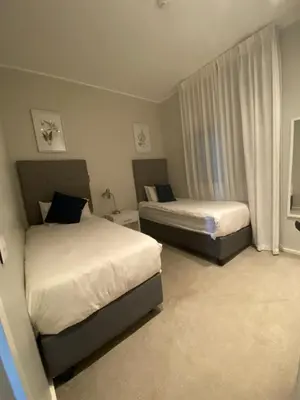 a bedroom with two beds and a window at Serene Global Capetown Axis in Cape Town