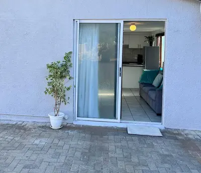 an open door to a living room with a plant at Cosy Flatlet in Chrismar in Stikland