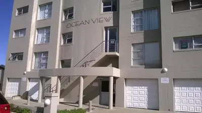 an apartment building with a staircase in front of it at Aandvari Ocean View in Cape Town