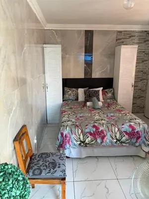 a bedroom with a bed and a chair at Browns villa and construction pty ltd in Cape Town