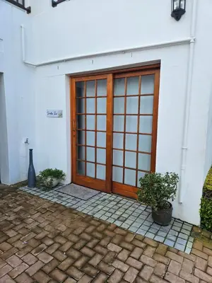 a door to a building with two potted plants at Protea Rus in Wellington