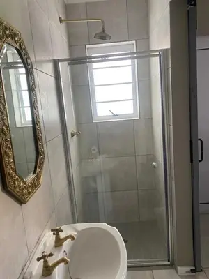 a bathroom with a shower and a sink and a mirror at The Perfect Spot in Welgelegen