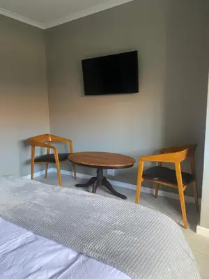 a bedroom with a table and two chairs and a tv at The Perfect Spot in Welgelegen