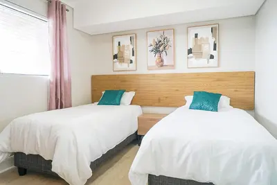 two beds sitting next to each other in a bedroom at Walk to Canal Walk - Modern Flat in Cape Town