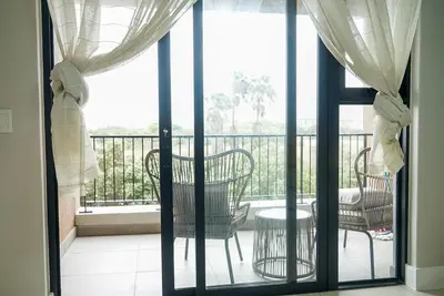 a balcony with chairs and a table on a balcony at Walk to Canal Walk - Modern Flat in Cape Town