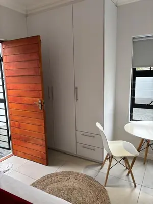 a room with a door and a chair and a table at Studio Apartment in Cape Town in Cape Town