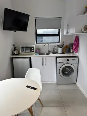 a small kitchen with a sink and a washing machine at Studio Apartment in Cape Town in Cape Town