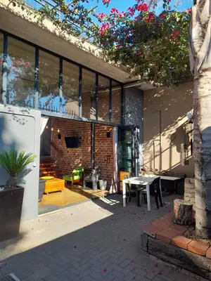 a patio of a house with a table and a tree at The Regiment Self Catering Accommodation has 3 x 4 sleeper units in Cape Town