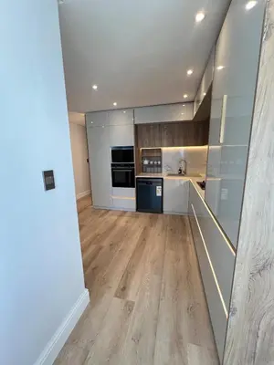 a large kitchen with wooden floors and stainless steel appliances at Luxury Portico Apartment in Cape Town