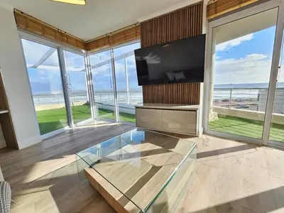 a living room with a tv and a glass table at Luxury Portico Apartment in Cape Town