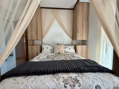 a bedroom with a large bed with a canopy at Kiwara at C, Gordon's Bay in Gordonʼs Bay