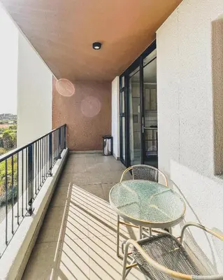 a patio with a table and chairs on a balcony at Modern One Bedroom Apartment Next to Canal Walk Mall in Cape Town